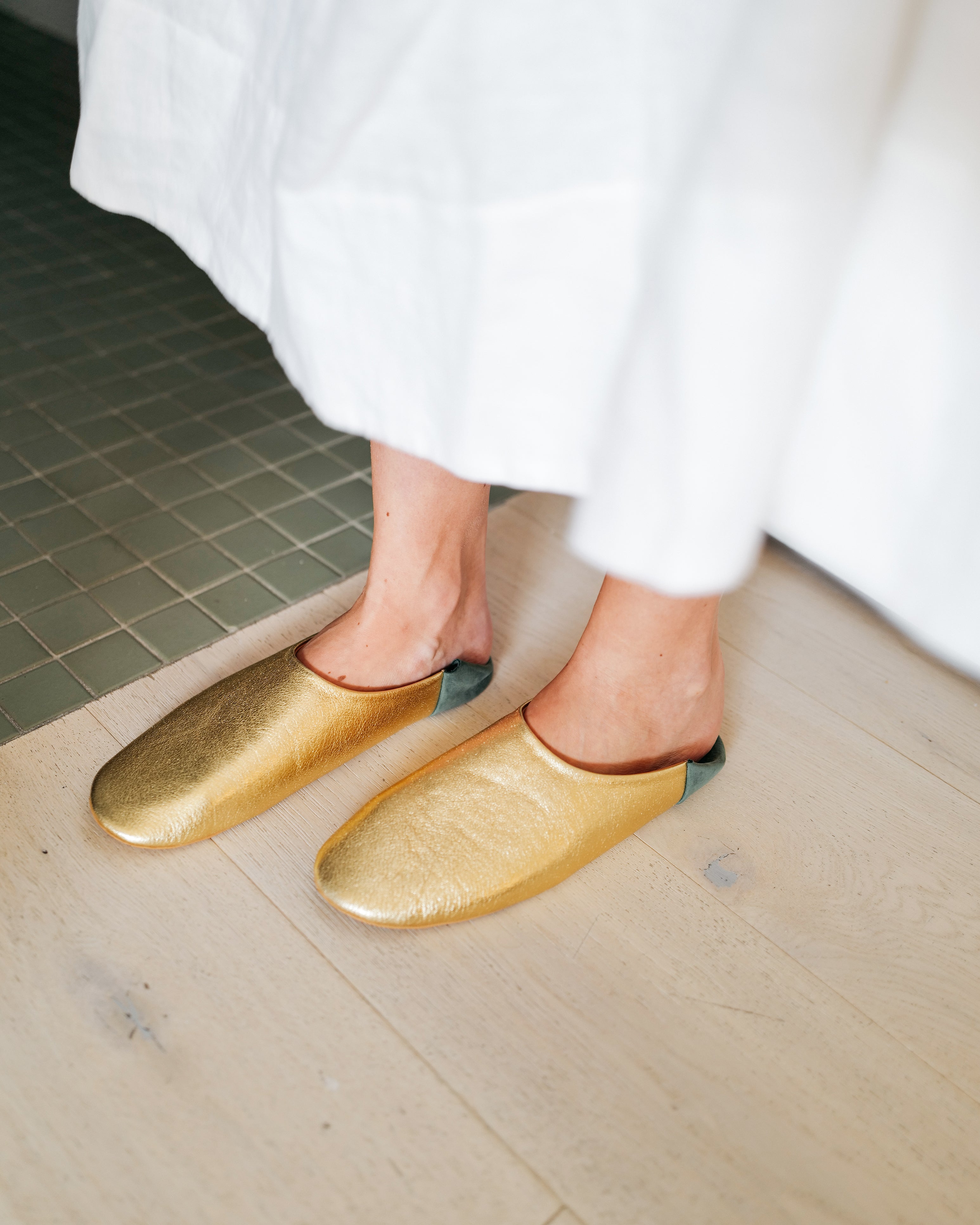 Womens luxury gold slippers on model